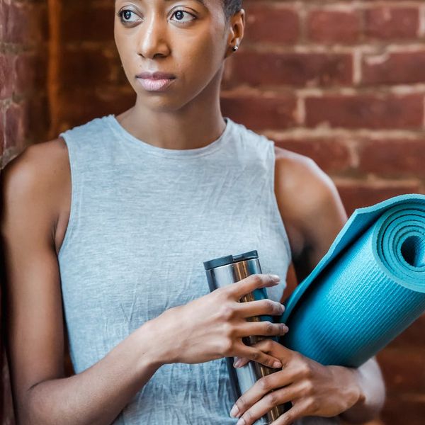 Yoga mat rolled out next to a water bottle and a small towel.